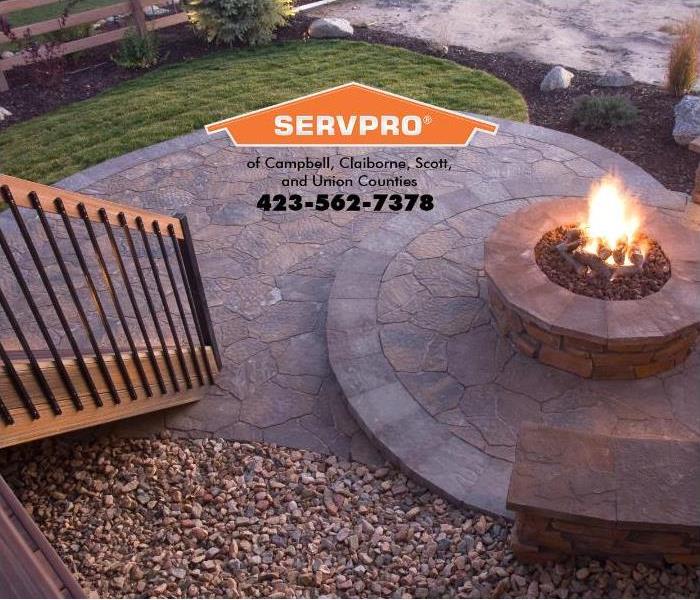An outdoor fire pit is shown next to a wooded deck.